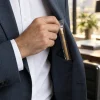 Main glissant un siwak ensaché dans la poche d'une veste de costume