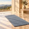 Tapis de prière uni bleu grisé dans un intérieur lumineux