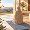 Femme en prière assise sur un tapis uni bleu grisé